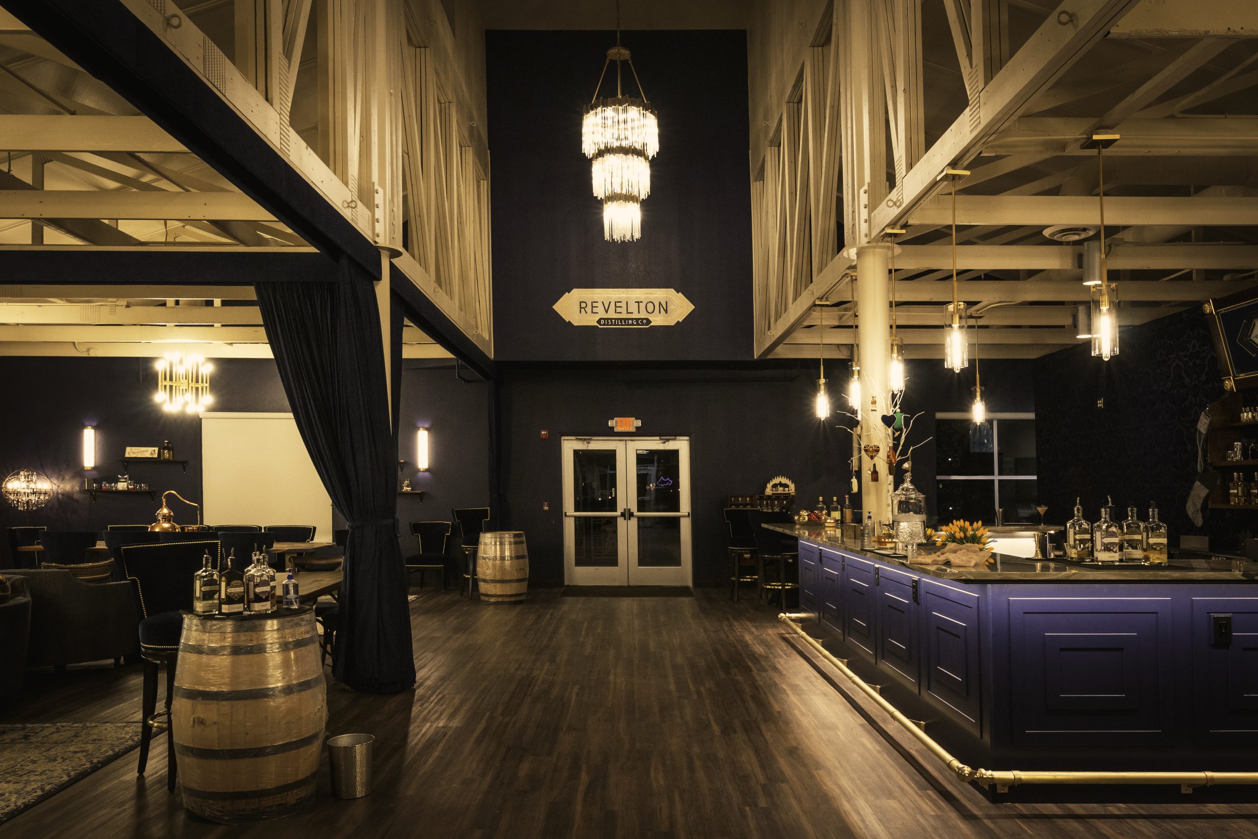 Revelton Distilling Company tasting room interior with bar, chandelier, and barrel seating, Osceola, Iowa